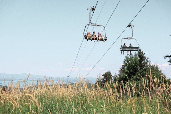 people on ski lift heading up to top of mountain