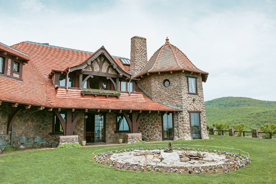 stone castle with red roof on top of mountain