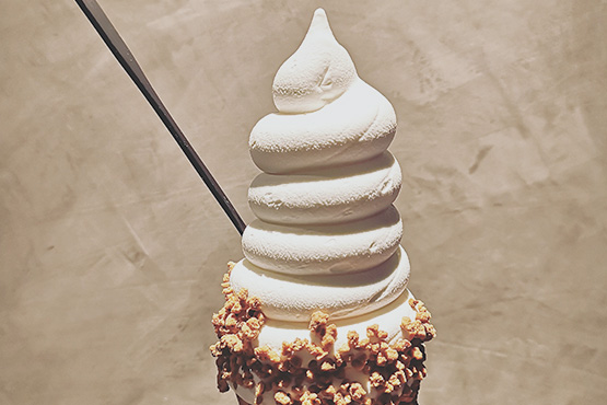 soft serve swirl ice cream with nuts on cone