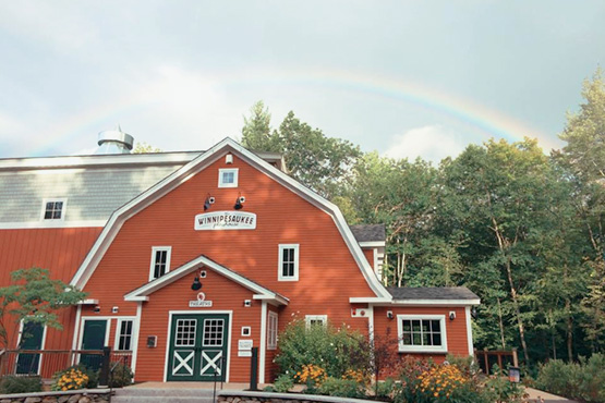 red barn with forest and rainbow in background