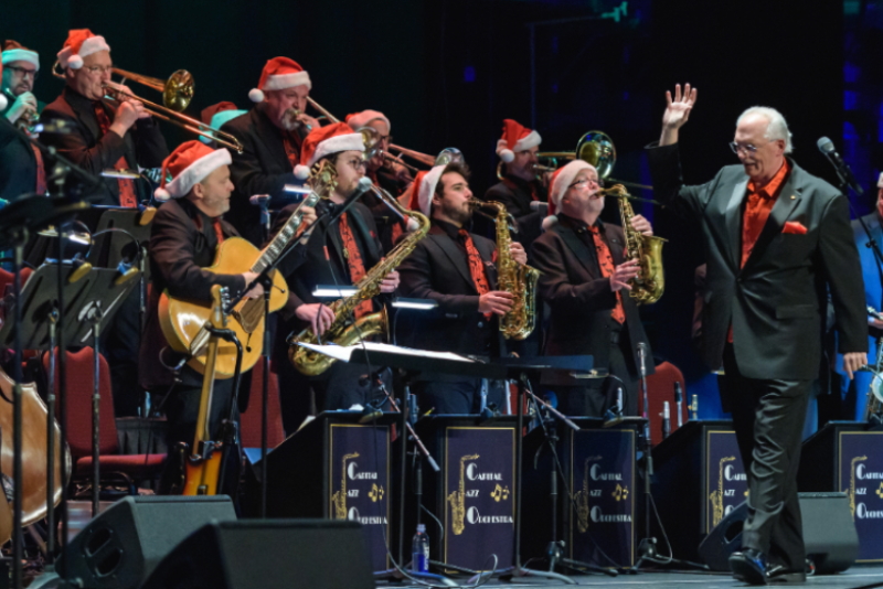 group of musicians playing holiday pops concert with santa hats on