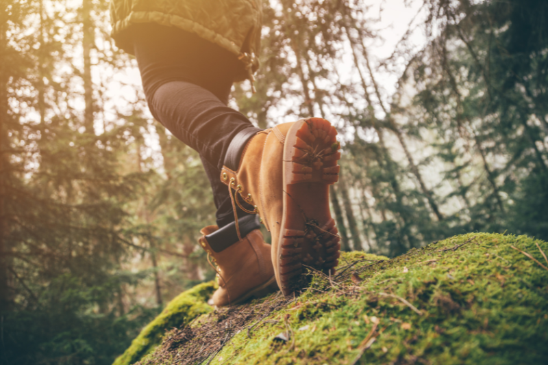woman in hiking boots on grass in forest