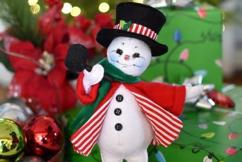 snowman doll dressed in red and green outfit with top hat