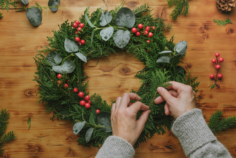 festive holiday wreath with cranberries on a wooden table