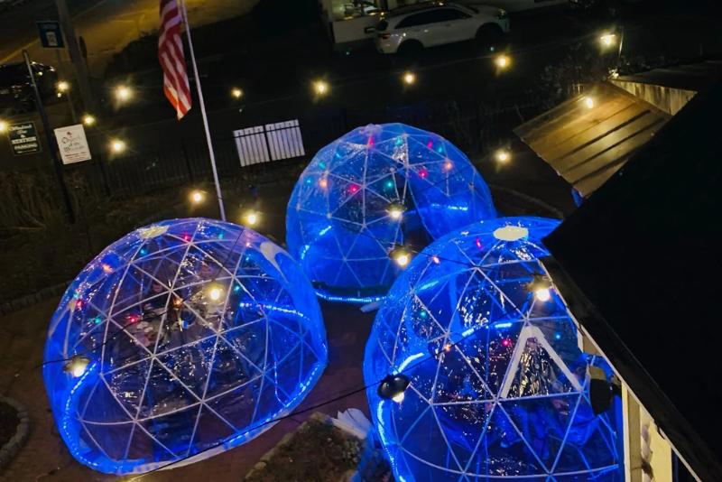 three outdoor igloos outside woodstock inn brewery at night