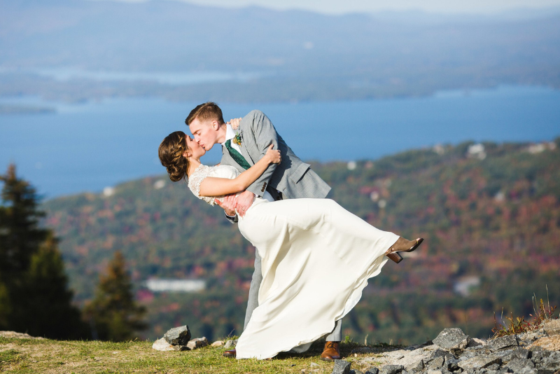groom dipping bride for a kiss atop gunstock mountain
