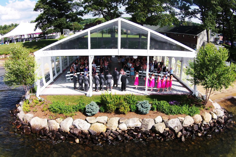 wedding reception under a tent against the edge of the water